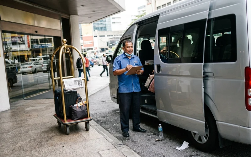 An air-conditioned tour van waiting outside a Kuala Lumpur hotel in the morning