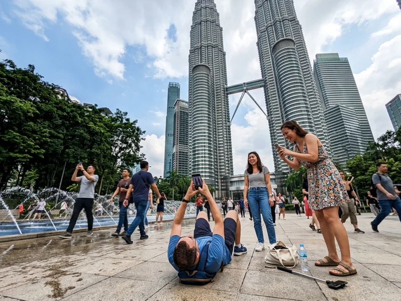 Visitors photographing the Petronas Twin Towers from the plaza