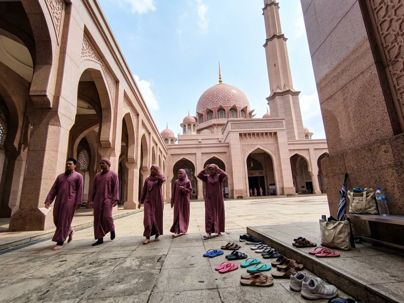 The pink granite facade and dome of the Putra Mosque seen from the courtyard