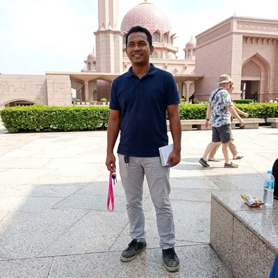 Gana, Tour Operations Lead at Putrajaya Tours, photographed outdoors near the Putra Mosque courtyard